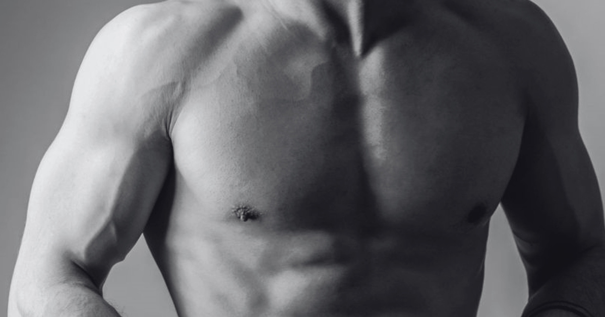 Black-and-white editorial crop of a bare chest and shoulders against grey